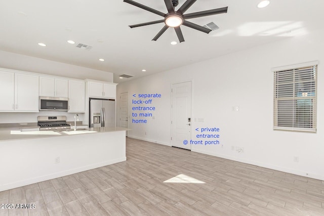 kitchen featuring light countertops, appliances with stainless steel finishes, a sink, and visible vents