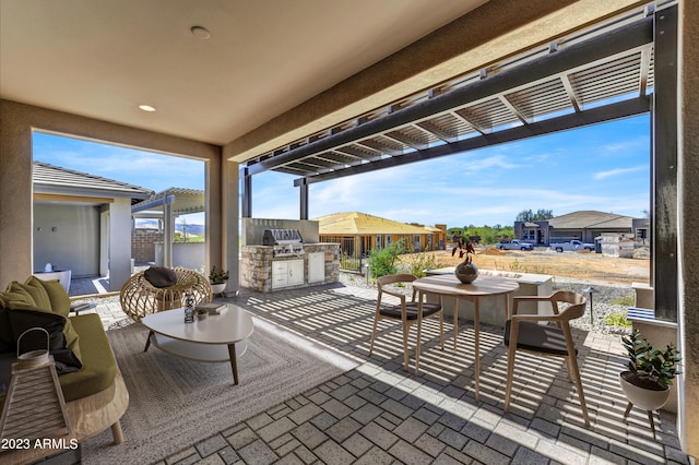 view of patio featuring exterior kitchen and a grill