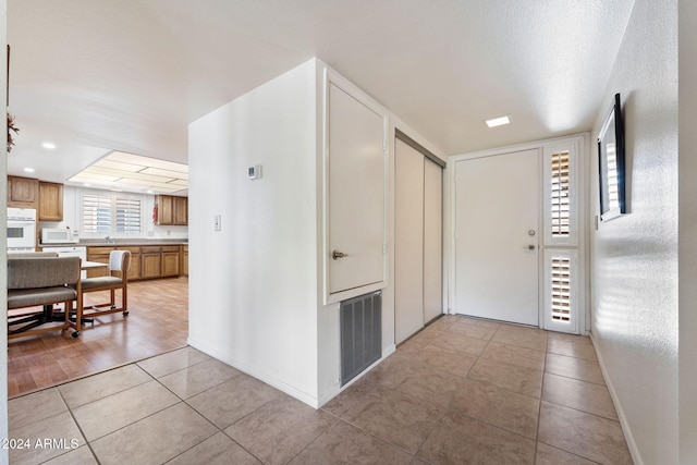 hallway featuring a textured ceiling and light wood-type flooring