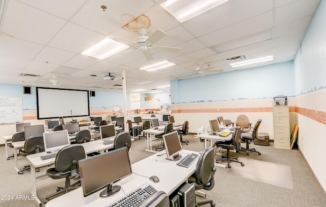 office area with ceiling fan, carpet flooring, and a paneled ceiling