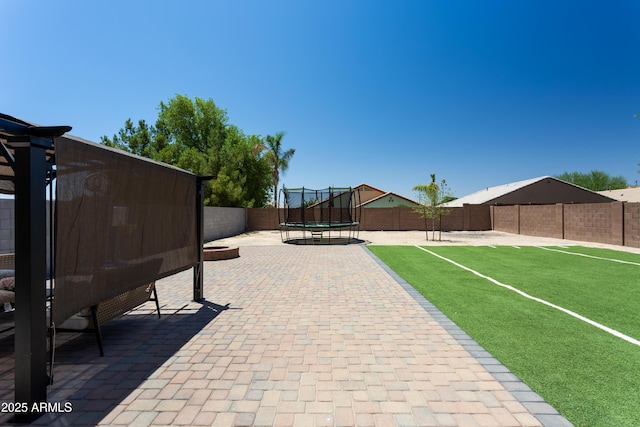 18575 W Vogel Ave, Goodyear, AZ 85338 - fenced backyard featuring a trampoline and a patio area