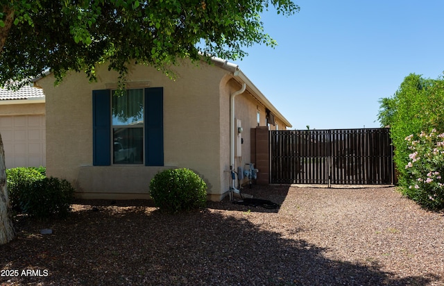 18575 W Vogel Ave, Goodyear, AZ 85338 - view of home's exterior featuring a gate, stucco siding, and an attached garage