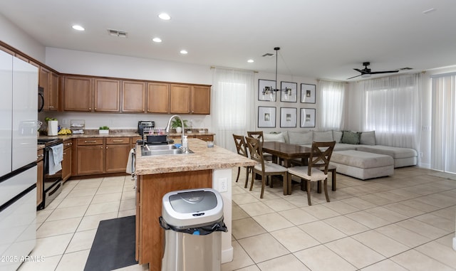 18575 W Vogel Ave, Goodyear, AZ 85338 - kitchen with black appliances, brown cabinetry, light tile patterned flooring, open floor plan, and a sink