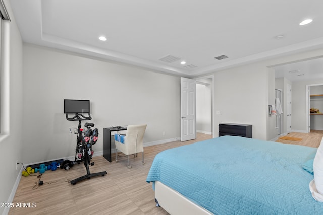 bedroom featuring baseboards, a raised ceiling, and recessed lighting