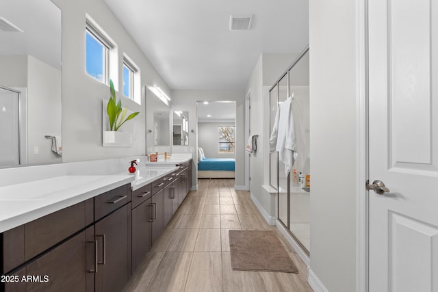 full bathroom featuring double vanity, a shower stall, and ensuite bathroom