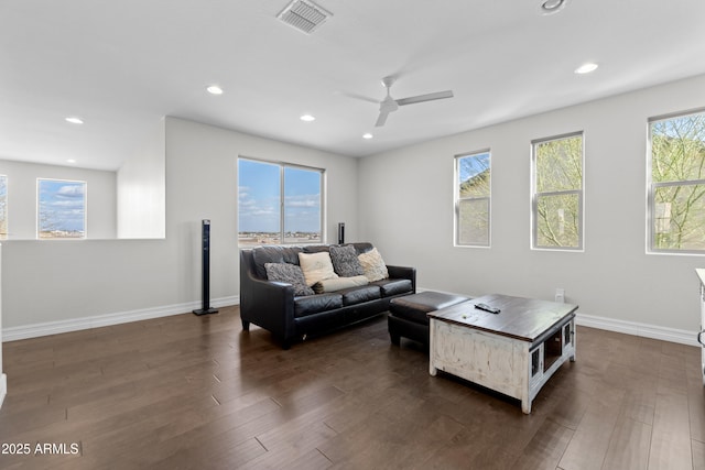 living area with baseboards, visible vents, dark wood finished floors, and recessed lighting