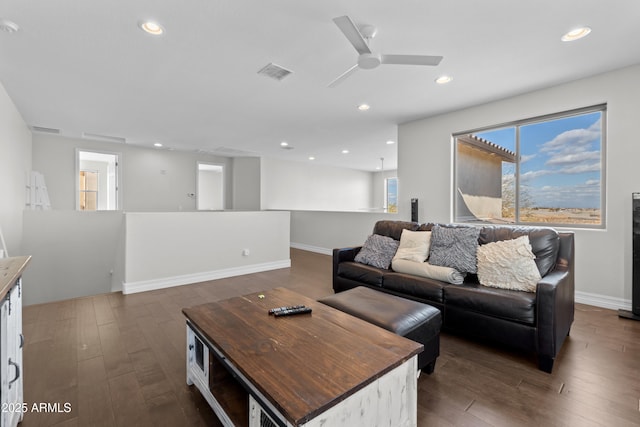 living room featuring recessed lighting, dark wood-style flooring, visible vents, and baseboards