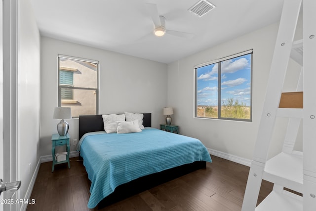 bedroom with ceiling fan, wood finished floors, visible vents, and baseboards