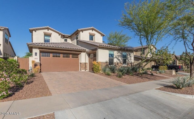 view of front facade featuring a garage, decorative driveway, a tile roof, and stone siding