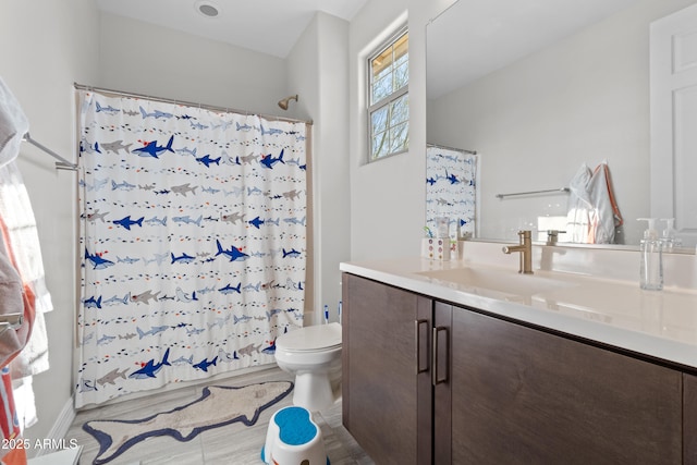 full bath with curtained shower, vanity, and toilet