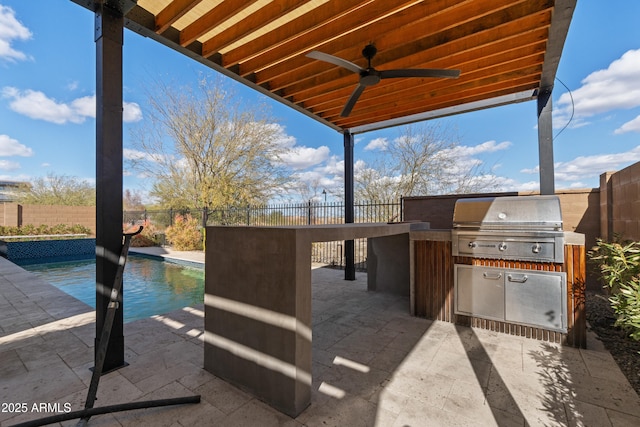 view of patio / terrace featuring grilling area, an outdoor kitchen, a fenced backyard, and a fenced in pool