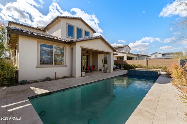 back of house with a fenced in pool, a patio, stucco siding, fence, and a tiled roof