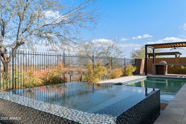 view of swimming pool with exterior kitchen, a fenced in pool, and a fenced backyard