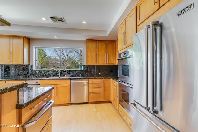 345 W Gardenia Dr, Phoenix, AZ 85021 - kitchen with visible vents, appliances with stainless steel finishes, dark stone countertops, a sink, and backsplash