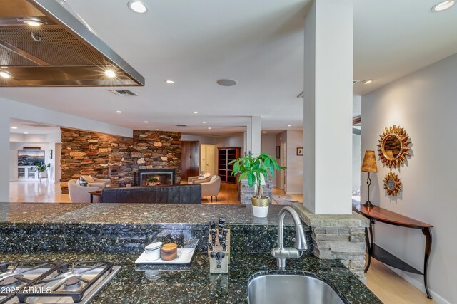 345 W Gardenia Dr, Phoenix, AZ 85021 - kitchen with recessed lighting, dark stone countertops, a sink, visible vents, and a fireplace