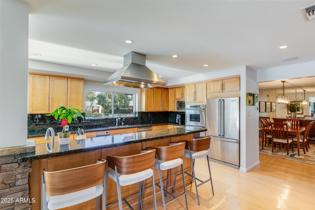 345 W Gardenia Dr, Phoenix, AZ 85021 - kitchen featuring island exhaust hood, light wood finished floors, backsplash, and stainless steel appliances