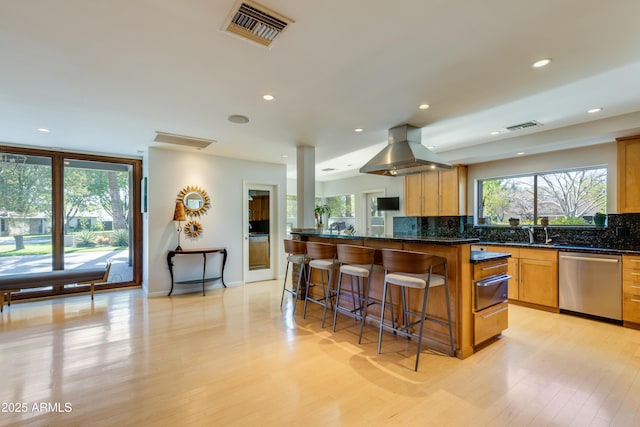 345 W Gardenia Dr, Phoenix, AZ 85021 - kitchen with light wood finished floors, a kitchen bar, dishwasher, visible vents, and decorative backsplash