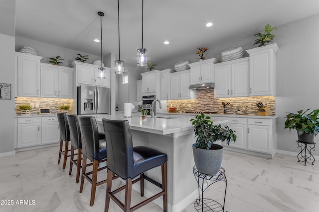 22837 E Silver Creek Ln, Queen Creek, AZ 85142 - kitchen with stainless steel appliances, marble finish floor, white cabinetry, and an island with sink