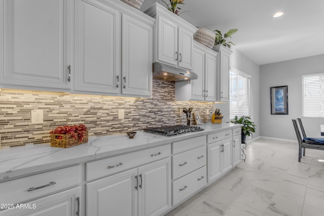 22837 E Silver Creek Ln, Queen Creek, AZ 85142 - kitchen with marble finish floor, stainless steel gas cooktop, backsplash, white cabinets, and under cabinet range hood