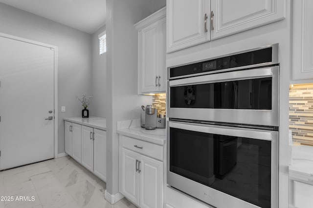 22837 E Silver Creek Ln, Queen Creek, AZ 85142 - kitchen with white cabinets, decorative backsplash, light stone counters, marble finish floor, and double oven