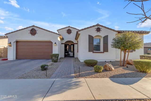 22837 E Silver Creek Ln, Queen Creek, AZ 85142 - mediterranean / spanish house featuring an attached garage, a tile roof, decorative driveway, and stucco siding