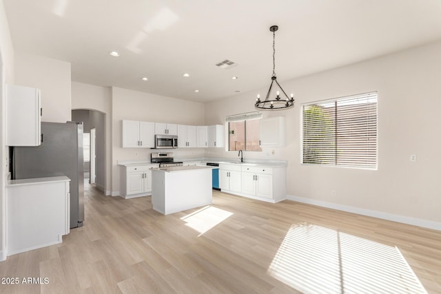 1112 E Winged Foot Dr, Chandler, AZ 85249 - kitchen with visible vents, stainless steel appliances, a kitchen island, arched walkways, and a sink