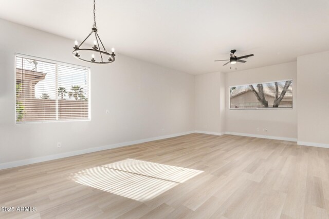 1112 E Winged Foot Dr, Chandler, AZ 85249 - empty room featuring ceiling fan with notable chandelier, baseboards, and light wood finished floors
