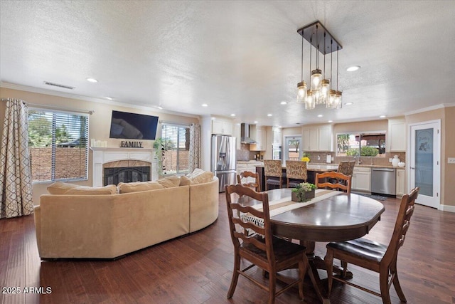 1670 E Whitten St, Chandler, AZ 85225 - dining room with crown molding, a fireplace, a textured ceiling, recessed lighting, and a chandelier