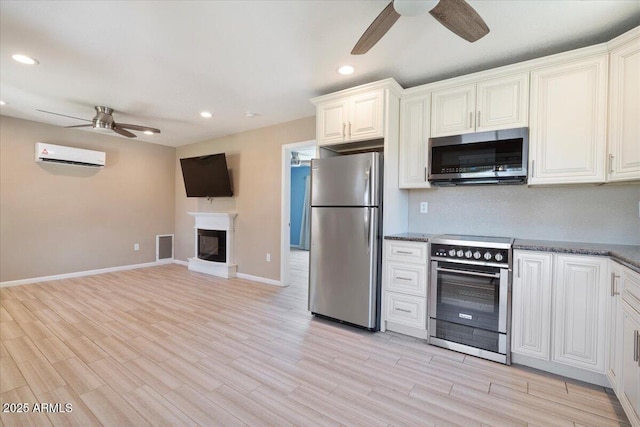 1670 E Whitten St, Chandler, AZ 85225 - kitchen featuring appliances with stainless steel finishes, a ceiling fan, a wall mounted AC, a glass covered fireplace, and recessed lighting