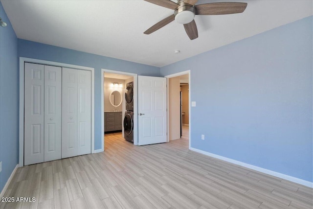 1670 E Whitten St, Chandler, AZ 85225 - unfurnished bedroom with stacked washer / dryer, baseboards, light wood-style floors, a closet, and ceiling fan