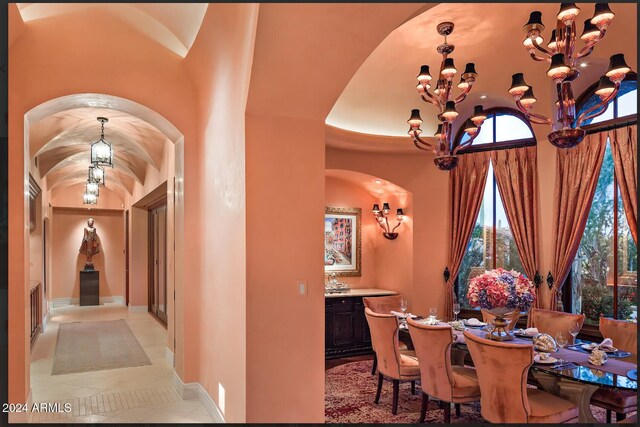 9808 E Honey Mesquite Dr, Scottsdale, AZ 85262 - dining space featuring a chandelier, tile patterned flooring, arched walkways, healthy amount of natural light, and a towering ceiling