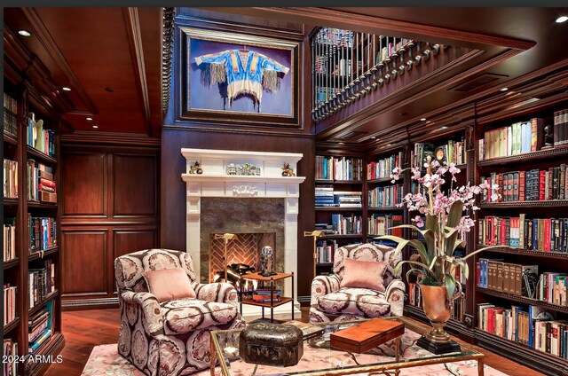 9808 E Honey Mesquite Dr, Scottsdale, AZ 85262 - living area with wall of books, dark wood-type flooring, a fireplace, and ornamental molding