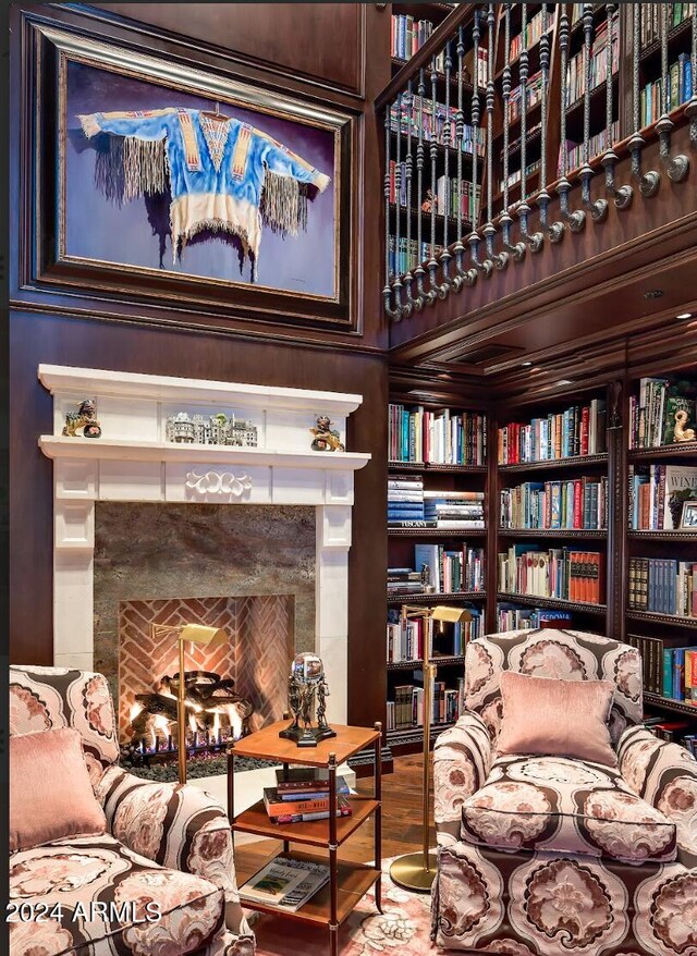 living area featuring built in shelves, hardwood / wood-style floors, and a fireplace