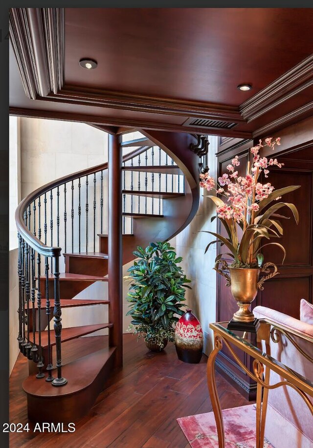 stairway featuring wood-type flooring and ornamental molding