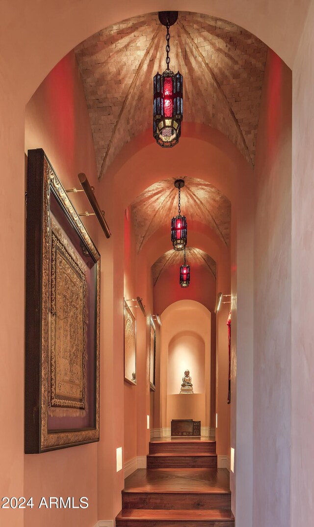 9808 E Honey Mesquite Dr, Scottsdale, AZ 85262 - hallway featuring lofted ceiling, arched walkways, brick ceiling, wood finished floors, and baseboards