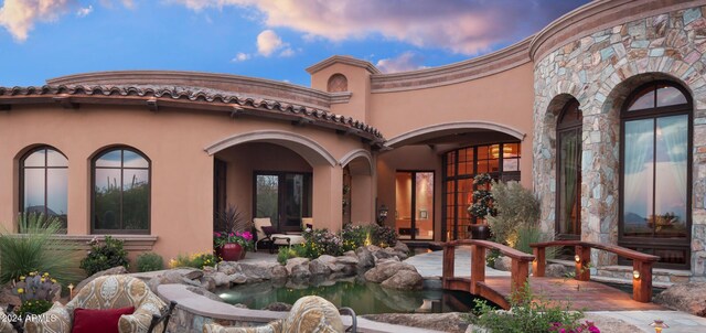 9808 E Honey Mesquite Dr, Scottsdale, AZ 85262 - rear view of house with stucco siding, stone siding, and a small pond
