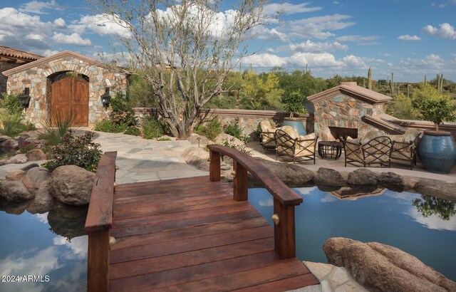 exterior space with a patio area and an outdoor stone fireplace