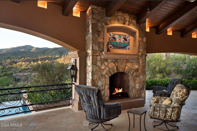 view of patio with an outdoor stone fireplace and a mountain view