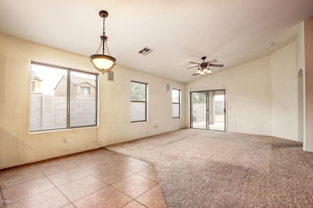 carpeted spare room featuring ceiling fan, plenty of natural light, and vaulted ceiling