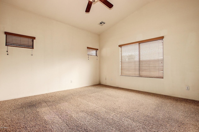 carpeted spare room featuring vaulted ceiling and ceiling fan