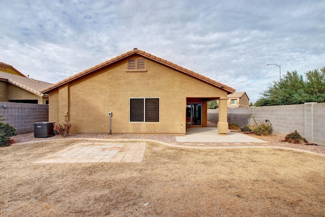 back of property featuring cooling unit and a patio