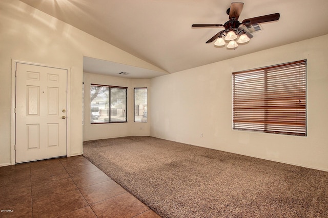 tiled empty room featuring vaulted ceiling and ceiling fan