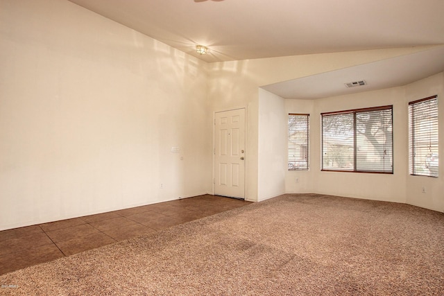 empty room with lofted ceiling and dark colored carpet