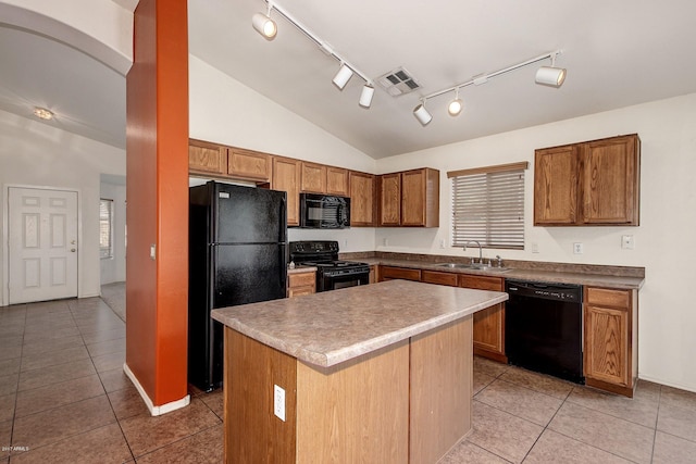 kitchen with a center island, sink, vaulted ceiling, light tile patterned floors, and black appliances