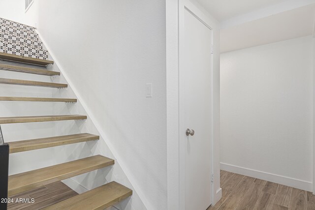 stairway with hardwood / wood-style floors