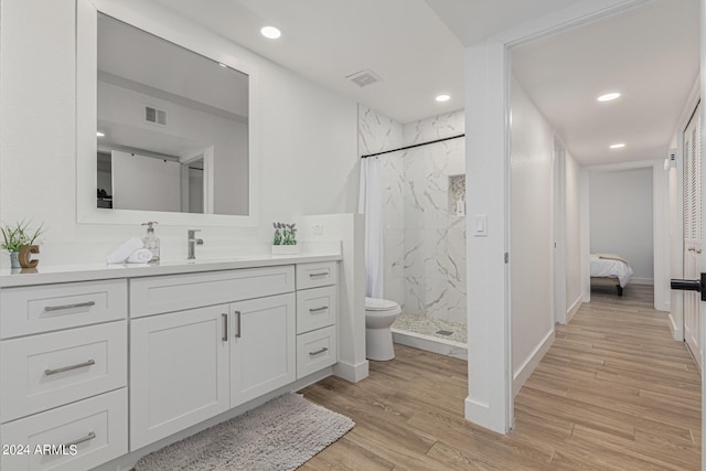 bathroom with vanity, hardwood / wood-style floors, and a tile shower