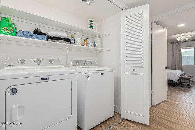 laundry area featuring light hardwood / wood-style flooring and washer and clothes dryer