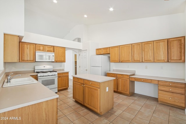 kitchen featuring a center island, white appliances, high vaulted ceiling, sink, and built in desk