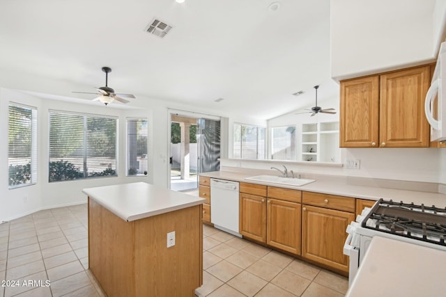 kitchen with a center island, lofted ceiling, white appliances, sink, and light tile patterned floors