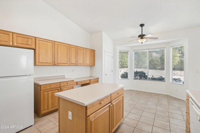 kitchen featuring ceiling fan, a kitchen island, lofted ceiling, white appliances, and light tile patterned floors